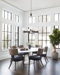 a dining room table with chairs and a potted plant in the middle of it