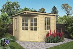 a small wooden shed sitting on top of a lush green field next to a flower garden