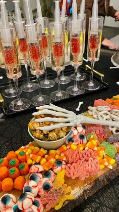 an assortment of desserts and champagne glasses on a table with people in the background