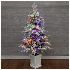 a small white christmas tree with multicolored lights