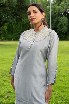 Grey three fourth sleeves curved hem kurta with dahlia pearls cut work detailing neckline. Paired with a pant. - Aza Fashions Spring Embellished Long Sleeve Kurta, Elegant Festive Kurta With Embroidered Hem, Traditional Long Sleeve Set With Embroidered Neckline, Resham Embroidery Kurta With 3/4 Sleeve, Festive Long Sleeve Kurta With Embroidered Hem, Festive Long Sleeve Embroidered Kurta, Elegant Cotton Tops For Designer Wear, Fitted Straight Kurta Set With Embroidered Neckline, Elegant Cotton Blouse With Embroidered Neckline