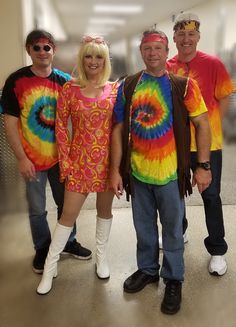 three men and a woman dressed in tie - dyed clothing