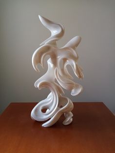 a white sculpture sitting on top of a wooden table