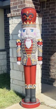 a red and gold nutcracker statue in front of a brick building