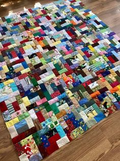 a very large patchwork rug made out of many different colored fabrics on the floor