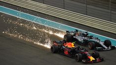 two red bull racing cars on a race track with water splashing from the tires