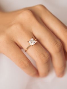 a woman's hand with a diamond ring on it