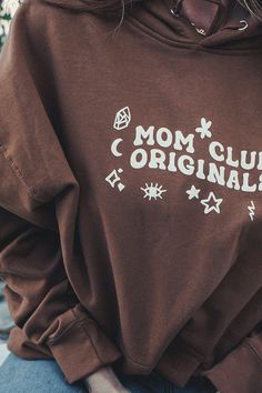 Get comfy in this classic brown colored hoodie. Mom Club Originals with doodle designs and a special puffy paint print texture. Size up if you want that oversized fit. Oversized Long Sleeve Brown Hoodie, Oversized Brown Long Sleeve Hoodie, Trendy Brown Long Sleeve Hoodie, Oversized Brown Hoodie Sweatshirt, Brown Graphic Print Long Sleeve Sweatshirt, Brown Long Sleeve Sweatshirt With Graphic Print, Brown Relaxed Fit Hoodie Top, Brown Cotton Graphic Print Sweatshirt, Oversized Brown Graphic Print Sweatshirt