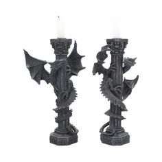 a pair of candles that are sitting next to each other on a white background with the candle in the shape of a dragon