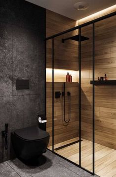 a modern bathroom with glass walls and wooden accents, along with a walk in shower