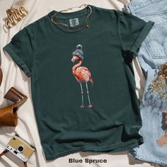 🦩 Cute flamingo in a beanie graphic tee, perfect for quirky fashion, trendy casual wear. Unique gift idea, fun bird print top.  Comfort Colors 1717 is a fully customizable tee made 100% with ring-spun cotton. The soft-washed, garment-dyed fabric brings extra coziness to your wardrobe while the relaxed fit makes it an excellent daily choice. The double-needle stitching throughout the tee makes it highly durable while the lack of side-seams helps the shirt retain its tubular shape.  SIZE AND FIT: Beanie Graphic, Flamingo T Shirt, Cute Flamingo, Quirky Fashion, Comfort Colors Tee, Bird Print, Animal Shirts, Bird Prints, Print Top