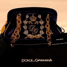 Blue Velvet Dolce & Gabbana Frame Bag With Gold-Tone Bronze Hardware, Metallic Gold-Tone Bronze Leather Trim, Dual Chain-Link Shoulder Straps, Gold Zip Closure And Beautiful Gold Leaf Details. Red Canvas Lining. Comes With Certificate Of Authenticity, Original Tags (Tags Are Detached) And Black Dust Bag. Never Used. Designer Rectangular Bag With Embroidered Logo, Luxury Shoulder Bag With Embroidered Logo And Top Handle, Elegant Top Handle Shoulder Bag With Embroidered Logo, Luxury Embroidered Top Handle Shoulder Bag, Designer Embroidered Top Handle Bag, Evening Bags With Embroidered Logo, Designer Shoulder Bag With Embroidered Logo, Designer Embroidered Rectangular Bag, Elegant Rectangular Bag With Embroidered Logo