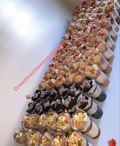 a long table filled with lots of different types of snacks and desserts next to each other