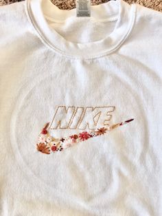 a white shirt with the word nike painted on it's chest and an arrow