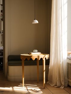 a wooden table sitting in front of a window next to a white radiator