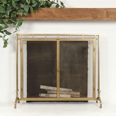 a fireplace with a gold frame and glass doors