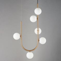 a chandelier with five lights hanging from it's sides and four balls on each end