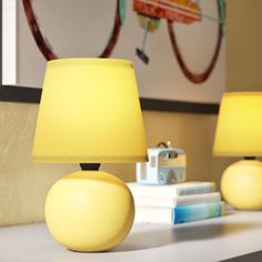 two yellow lamps sitting on top of a table