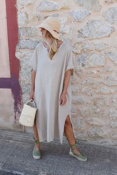 Style // Whether you call it beige, cream, off-white, one thing is for sure - our Moon tone is absolutely perfect! When comfort meets style, the Cala Kaftan features a billowy, shapeless silhouette and mid-length. With a v-neck silhouette, wide sleeves and two side slits, it promises to be your go-to look for that cozy, effortless look. The lightweight linen-cotton blend fabric is extra soft, to ensure you won't ever want to take it off. Fit Note: Available in one size fits most. Bust: 64" Lengt Casual V-neck Kaftan For Daywear, Beige Kaftan For Spring Daywear, Casual Beige Kaftan For Spring, Spring Linen V-neck Kaftan, Casual V-neck Relaxed Fit Kaftan, Casual Linen V-neck Kaftan, Beige V-neck Kaftan For Vacation, Oversized Neutral Summer Dress, Beige Summer Kaftan For Loungewear