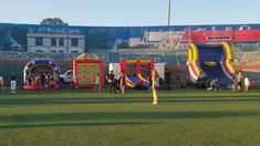 inflatable bouncy houses are set up on the field for kids to play