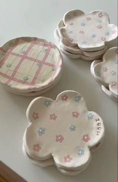 four plates with flower designs on them are sitting on a counter top next to each other