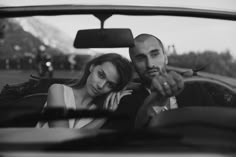 a man and woman sitting in the back seat of a car