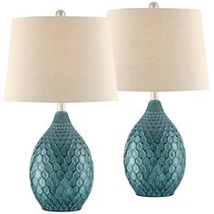 two blue ceramic lamps with white shades on them