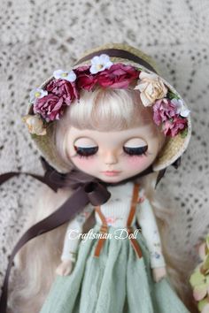 a doll wearing a hat with flowers on it