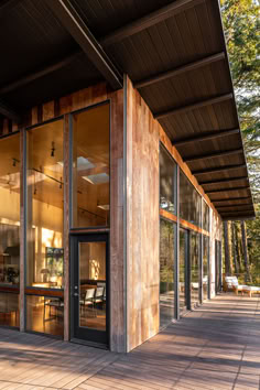 the outside of a building with glass doors and wood sidings on it's sides