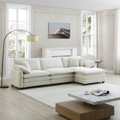 a living room with white furniture and large windows