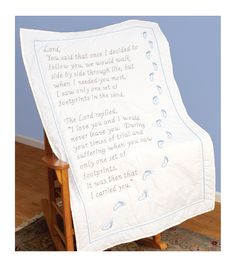 a white blanket with blue writing on it sitting on top of a wooden chair next to a rug