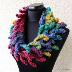 a multicolored crocheted scarf on a mannequin