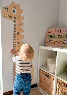 a toddler standing in front of a growth chart