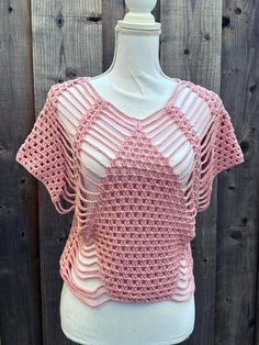 a pink crocheted top on a mannequin