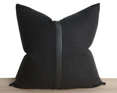 a black pillow sitting on top of a wooden table