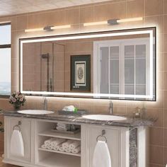 a bathroom with two sinks and a large mirror over the sink in front of it