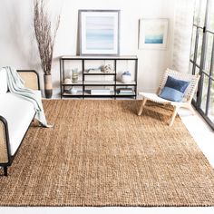 a living room with an area rug and chairs