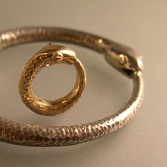 "A little guy that actually does seem to have a baby face! This piece is done in 14k gold, and measures 1/2\" across. It would display nicely on almost any gold chain. The large ouroboros in these photos is for display only in this listing....The large ouro is in another listing if you are interested." Antique Snake-shaped Yellow Gold Jewelry, Bronze Snake-shaped Jewelry Gift, Bronze Snake-shaped Jewelry For Gift, Bronze Snake Shape Jewelry As Gift, Antique Gold Snake-shaped Jewelry, Hand-forged Snake-shaped Jewelry For Gifts, Adjustable Hand Cast Yellow Gold Jewelry, Adjustable Hand-cast Yellow Gold Jewelry, Unique Yellow Gold Snake Ring