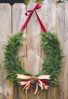 a christmas wreath hanging on a wooden fence