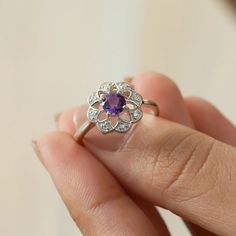 Sometimes when a girl says she likes to receive flowers as a gift, it's not the real flowers she meant. Think twice and go for the safest thing - our Flora ring with amethyst and side Moissanites. Floral jewelry is where it's at! Perfect as a graduation gift, birthday gift, anniversary ring, or a promise ring. Details: Center stone Gemstone: Amethyst Stone Shape: Round Measurements: 5.00mm Side stones Gemstone: Moissanite Shape: Round Measurements: 1.30mm (8) Band measurements: approx. 1.8mm wid Flower Shaped Gemstone Ring For Promises, Diamond Flower Ring With Birthstone As A Gift, Gemstone Flower Ring For Anniversary, Flower Shaped Gemstone Ring For Anniversary, Flower Shaped Gemstone Ring For Gift, Flower Shaped Gemstone Rings For Gifts, Flower Shaped Gemstone Ring Gift, Flower Shaped Ring With Prong Setting For Gift, Flower Shaped Ring With Center Stone As A Gift