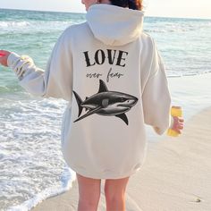 Dive into comfort with our Unisex Shark Hoodie, featuring a stunning vintage Great White Shark graphic. Perfect for those who love the oversized style, this sweatshirt is not only a stylish statement but also a cozy and soft addition to any shark lover's wardrobe. An ideal gift for marine enthusiasts, this sea animal hoodie offers a relaxed fit that's great for layering on chilly beach days or casual outings. Whether you're passionate about ocean conservation or simply admire the majesty of shar Shark Sweatshirt, Surf Hoodie, Christian Crewneck, Beach Hoodie, Shark Hoodie, Coconut Girl, Ocean Inspired, Whale Shark, Faith Over Fear