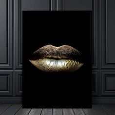 a black and gold lips poster on the wall in a room with wooden floors, dark walls