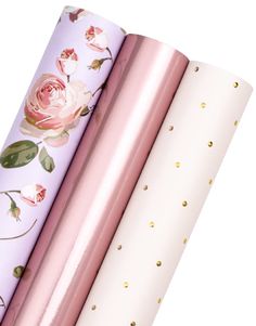 three rolls of wrapping paper with pink roses on them and gold dots around the edges