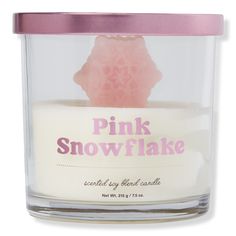 the pink snowflake candle is in a glass container