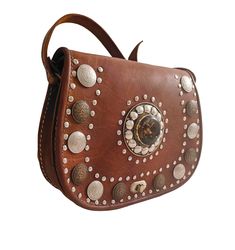 Shoulder bag, brown color, boho style, with rivets and rhinestones, with handle to hang from the shoulder, handmade Brown Leather Bags With Rivets, Hand Tooled Brown Shoulder Bag For Festivals, Hand-tooled Brown Shoulder Bag For Festivals, Handmade Brown Bohemian Saddle Bag, Brown Satchel Saddle Bag For Festivals, Brown Crossbody Saddle Bag For Festival, Brown Leather Saddle Bag For Festival, Brown Festival Crossbody Shoulder Bag, Brown Crossbody Shoulder Bag For Festival