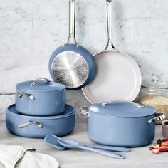 blue pots and pans are sitting on the counter next to other kitchen utensils