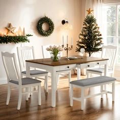 a dining room table with chairs and a christmas tree