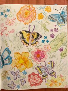 a drawing of butterflies and flowers on a piece of paper with colored crayons