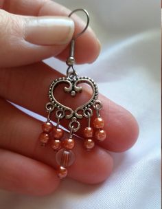 Beautiful, handmade earrings. Made with copper colored plastic beads, hung from an intricate sterling silver plated heart-shaped connector. These earrings would make the perfect gift for a special person's Birthday, Anniversary, or just to say "I'm thinking of you". *Size: about 2 inches long by 3/4 inch wide. * Very light weight. We do many custom orders and would love the chance to help you with the perfect gift! Metal Heart Beaded Earrings For Gifts, Metal Heart Beads Earrings For Gifts, Heart Beaded Metal Earrings As Gift, Metal Heart Bead Earrings As Gift, Heart Beads Metal Earrings For Gift, Heart Beads Metal Earrings As Gift, Gift Metal Heart Earrings With Heart Beads, Elegant Heart Beads Earrings, Heart-shaped Silver Copper Jewelry