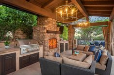 an outdoor kitchen and living room area with grill, couches, table and chairs